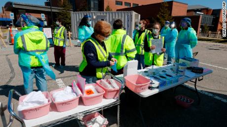 Health care workers prepare their supplies Wednesday at a coronavirus drive-thru testing site at Michigan&#39;s Henry Ford West Bloomfield Hospital.