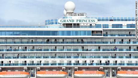 Passengers look out from aboard the Grand Princess cruise ship, operated by Princess Cruises, as it maintains a holding pattern about 25 miles off the coast of San Francisco, California on Sunday.
