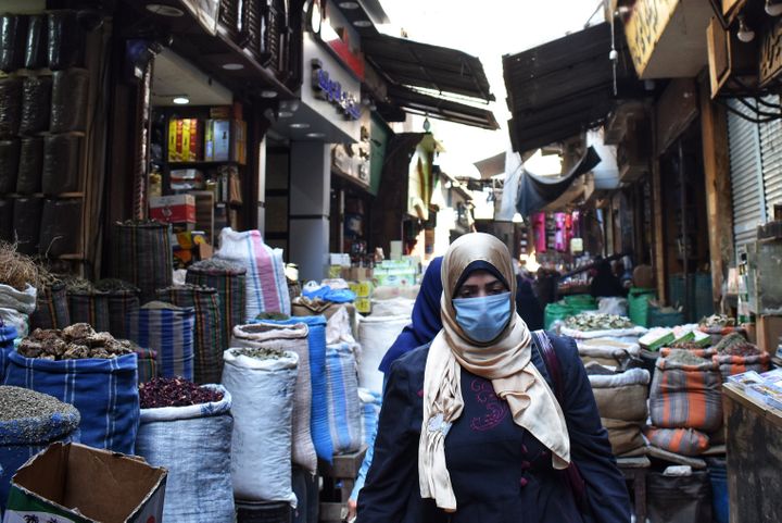 A woman walks through an&nbsp;Al Azhar district street market&nbsp;where people usually buy spices and herbs to prepare for R