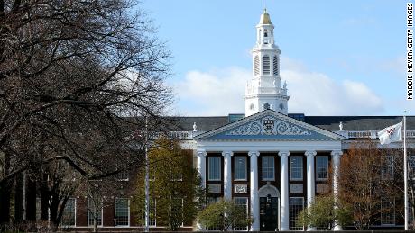 A runner crosses an empty Harvard Yard last month, after students were asked to finish the semester online.