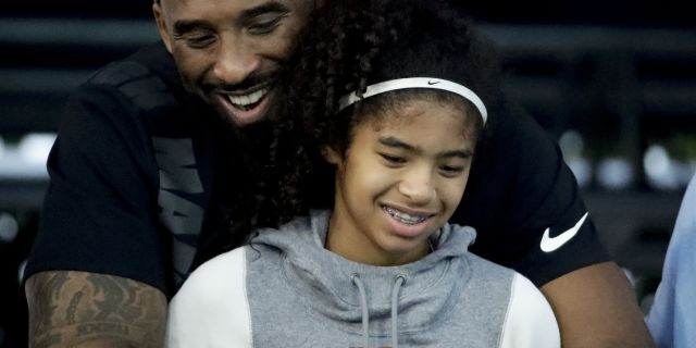 Kobe Bryant and his daughter Gianna watch during the U.S. national championships swimming meet in Irvine, Calif. 