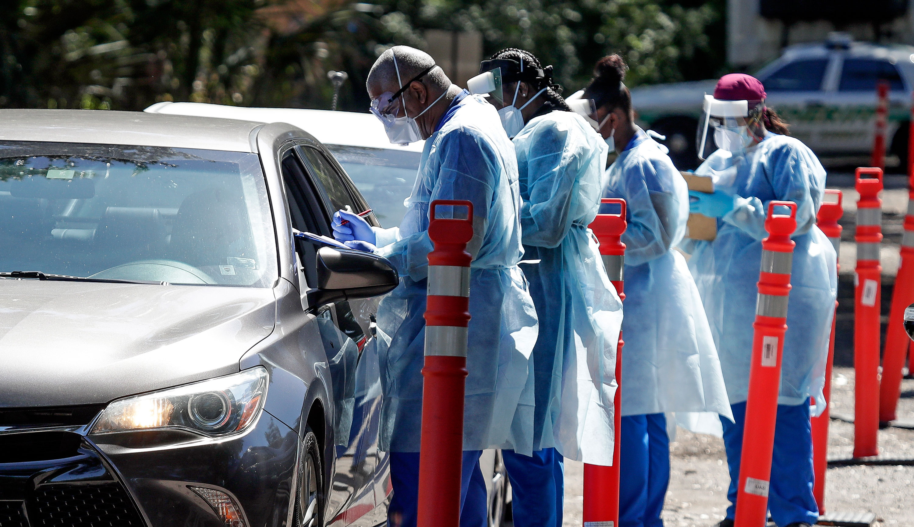 Health workers conduct Covid-19 tests at a drive-through testing site in Sanford, Florida on April 27.