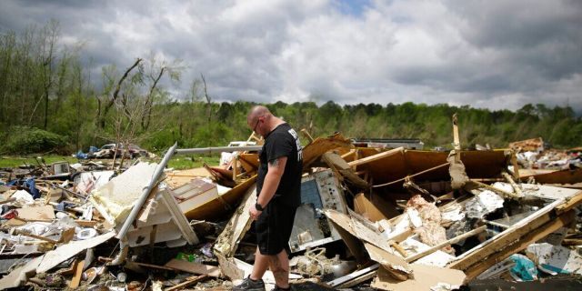 Aaron Pais kicks around debris at a mobile home park after a tornado hit on Monday, April 13, 2020, in Chatsworth, Ga. Severe weather has swept across the South, killing multiple people and damaging hundreds of homes from Louisiana into the Appalachian Mountains. Many people spent part of the night early Monday sheltering in basements, closets and bathroom tubs as sirens wailed to warn of possible tornadoes.