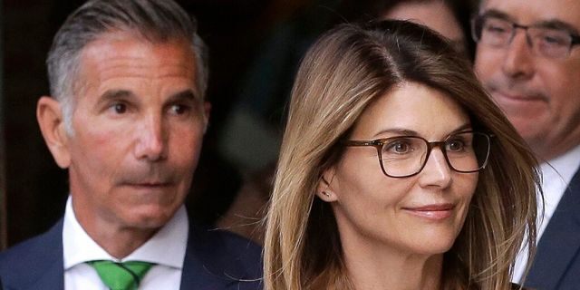 FILE - In this April 3, 2019, file photo, actress Lori Loughlin, front, and her husband, clothing designer Mossimo Giannulli, left, depart federal court in Boston. 