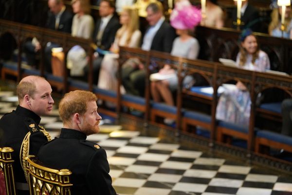 Prince Harry and Prince William sitting down in the chapel.