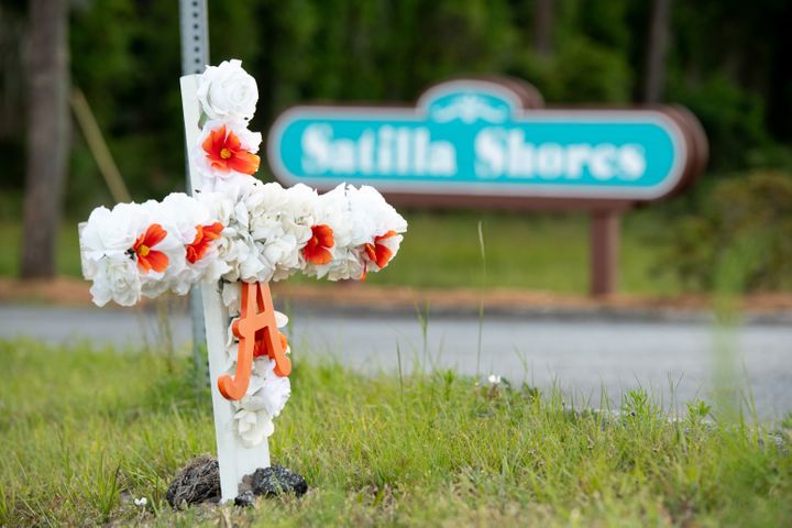 A cross with flowers and a letter "A" sits at the entrance to the Satilla Shores neighborhood where Ahmaud Arbery was shot an