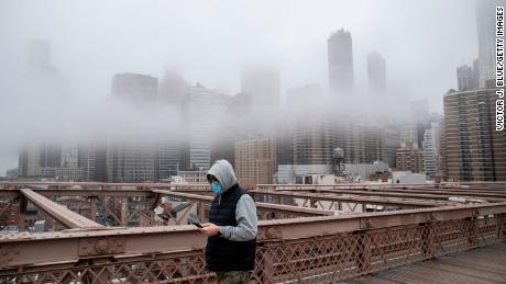 A man wearing a mask walks the Brooklyn Bridge in the midst of the coronavirus outbreak in New York City.