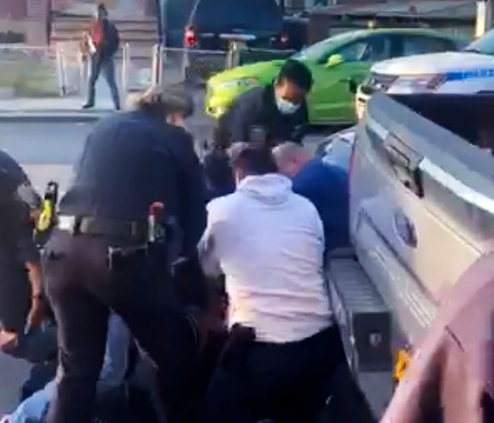 New York City police officers wrestle a man to the ground while making an arrest in the Brooklyn borough of New York on April