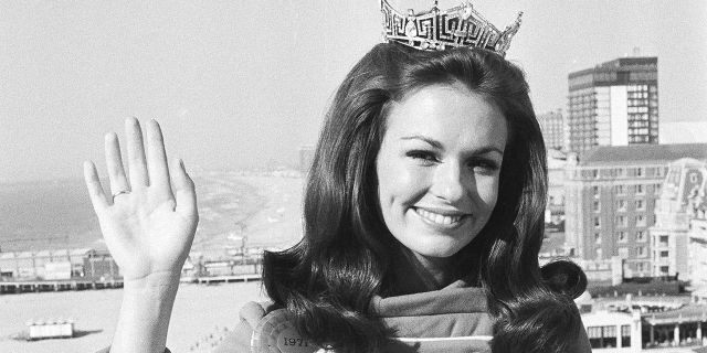 Phyllis George of Denton, Texas, the 21-year-old newly crowned Miss America, waves against backdrop of the beach and ocean at Atlantic City, N.J., Sept. 13, 1970. (Associated Press)