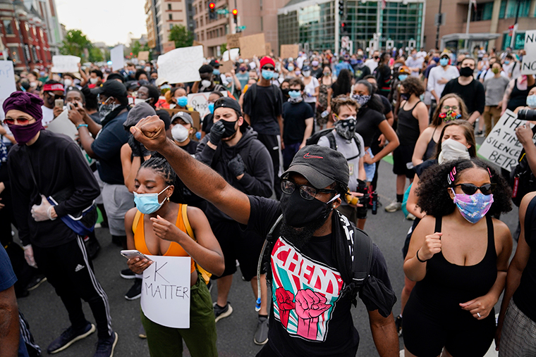 Demonstrators gather at the corner of 14th and U streets in Washington, Friday, May 29.
