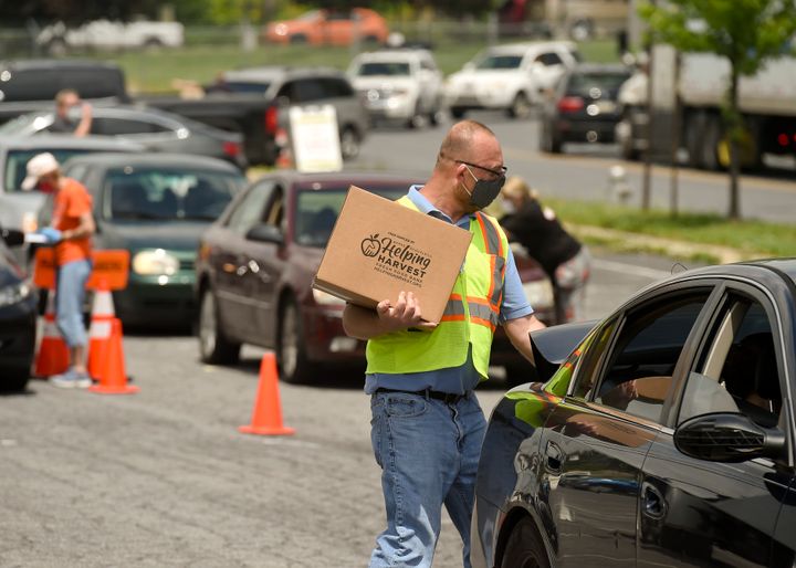 James Walton of Helping Harvest carries a box of food to a car during a pop-up food distribution in Reading, Pennsylvania, on May 29.