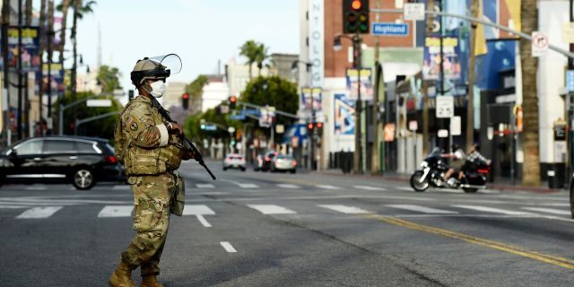 A U.S. National Guard soldier watches over Hollywood Blvd., Sunday, May 31, 2020, in Los Angeles.