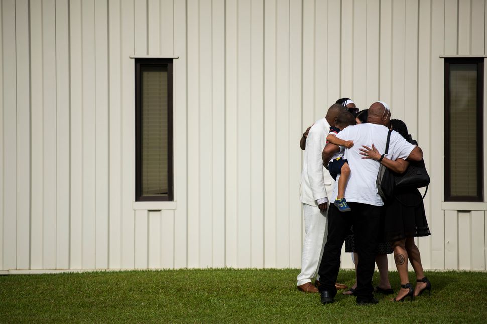 A group of people exiting a memorial for Floyd embrace each other outside the R.L. Douglas Cape Fear Center on June 6.