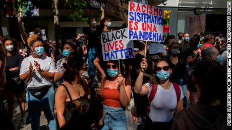 In Madrid, a protester warns that &quot;Systemic racism is a pandemic.&quot; 