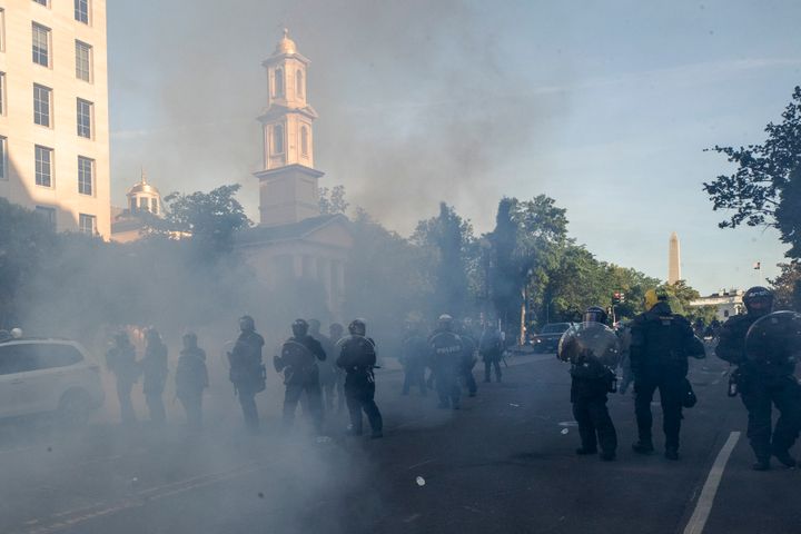Tear gas floats in the air as a line of police moves demonstrators away from St. John's Church across Lafayette Park on June 