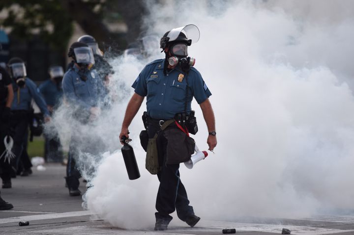 Law enforcement officers stand guard after tear gas is deployed near 47th and Main streets in Kansas City, Missouri, on May 3