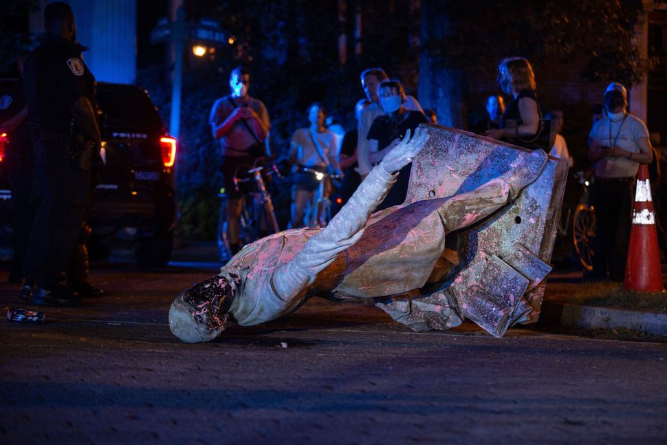 A statue of Confederacy President Jefferson Davis lies on the street after protesters pulled it down in Richmond, Virginia, o
