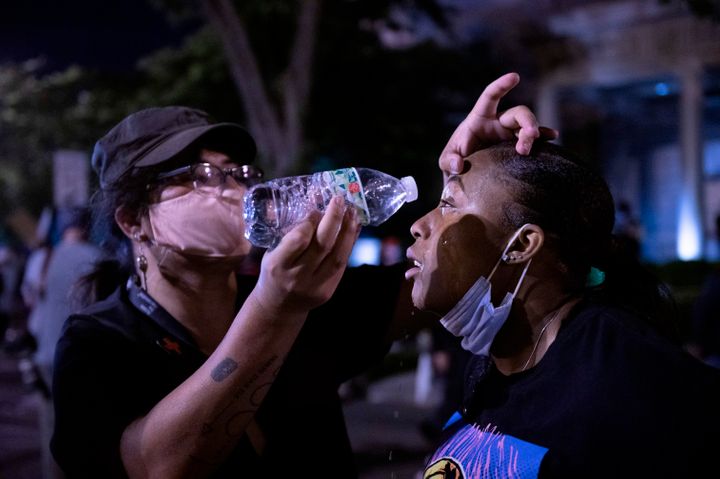 A protester rinses the eyes of another with water after police fired tear gas during a protest on May 31.