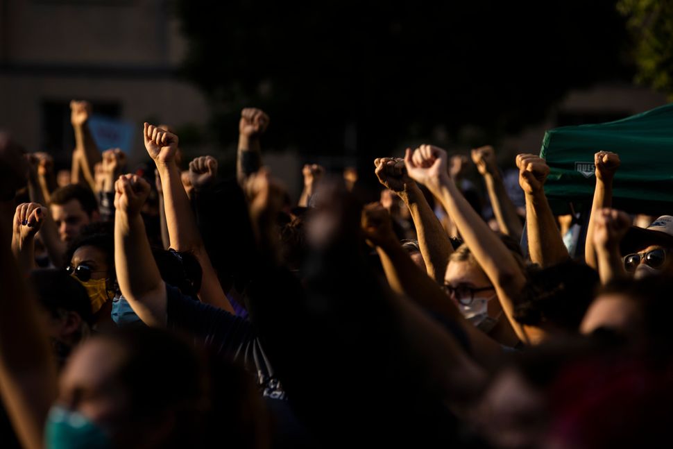 Protesters raise their fists in solidarity while listening to a speaker on June 5 in Louisville, Kentucky. Booker's presence 