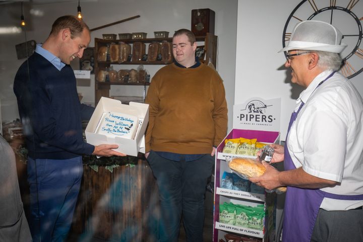 William is presented&nbsp;with a birthday cake by shop owner Paul Brandon (right).