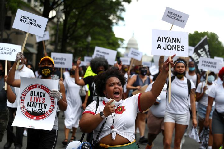 Juneteenth demonstrators march down Pennsylvania Avenue while holding signs bearing the names of Black transgender women kill