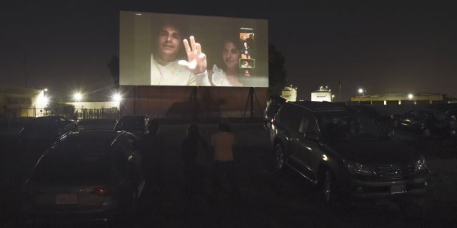 Dave Franco, left, director/co-writer of "The Rental," and his wife, cast member Alison Brie, are seen on a movie screen as they take part in a Zoom Q&amp;A session from their car following an advance screening of the film at the Vineland Drive-In, Thursday, June 18, 2020, in City of Industry, Calif. (AP Photo/Chris Pizzello)