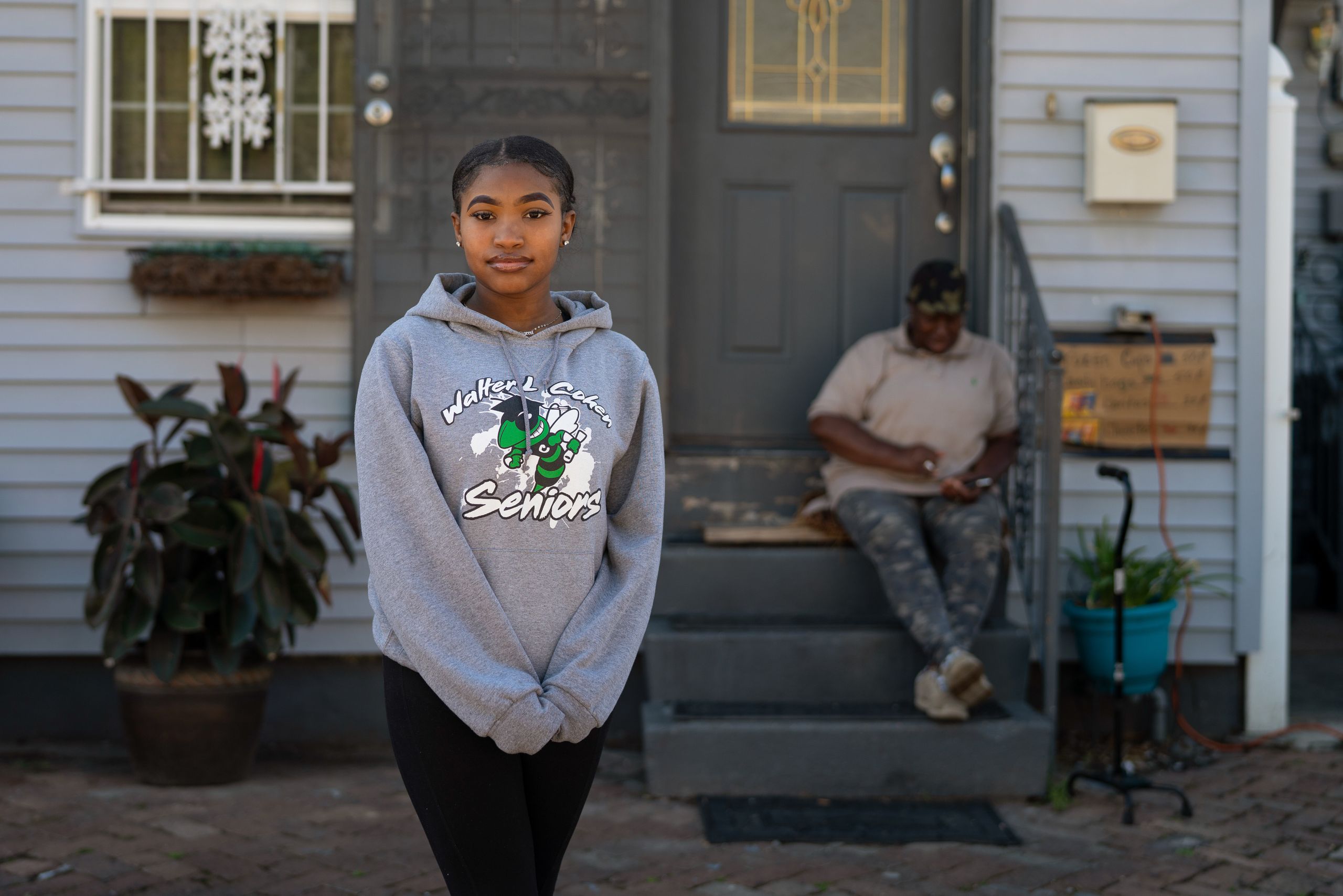 Satoriya Lambert stands in front of her home where she lives with her grandmother, Ether Bullock, 70, a retired teacher, who 