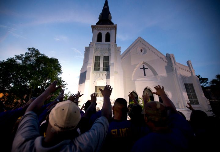 The men of Omega Psi Phi Fraternity Inc. lead a crowd of people in prayer outside the Emanuel AME Church in June 2015 after a
