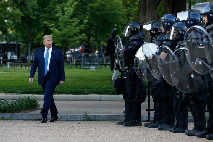 President Donald Trump walks past police in Lafayette Park after visiting St. John's Church across from the White House on Mo