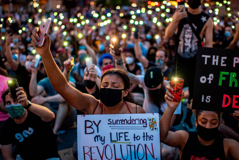 Protesters hold up their phones outside the White House on June 3 during a demonstration against police brutality and the kil