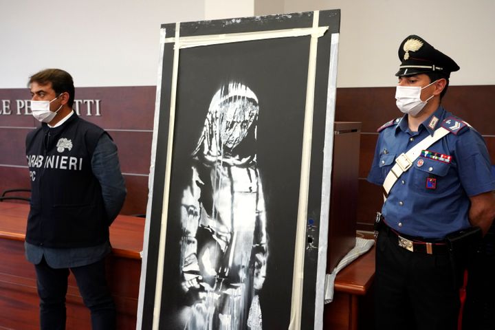Italian authorities unveil a stolen artwork painted by Banksy as a tribute to the victims of the 2015 terror attacks at the B