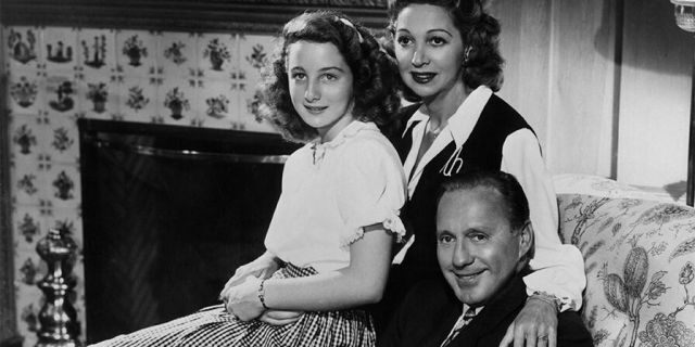 Family portrait of American comedian Jack Benny, his wife, Mary Livingstone, and their teenage daughter Joan Benny, seated together in a living room, circa 1945.