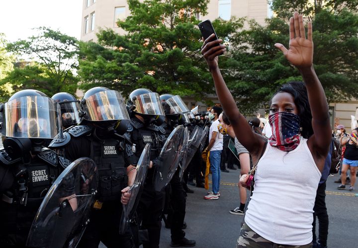 A protester stands, arms in the air, in front of a row of officers during a demonstration near the White House on June 1.