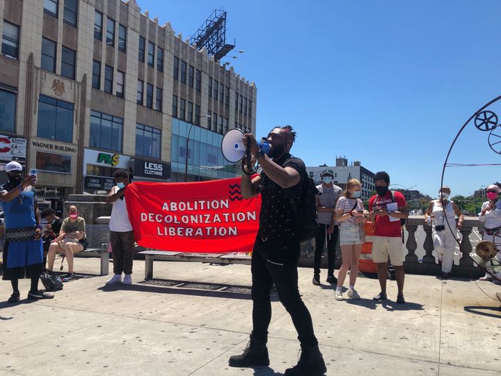 A demonstrator in the Bronx's Fordham neighborhood makes the case against the New York borough's true despoilers during "A Pe