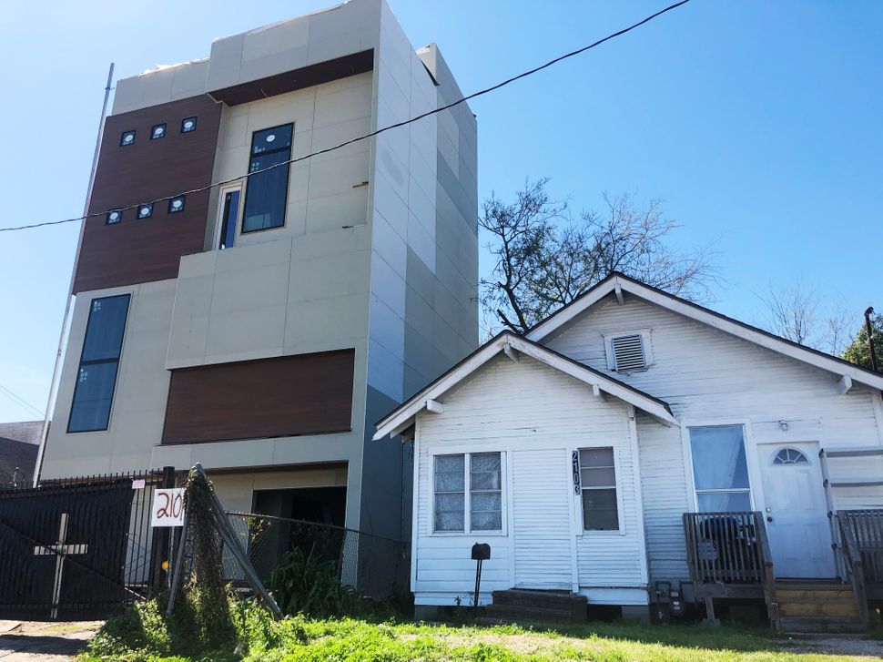 A newer apartment building built after Harvey (left) squeezes next to a pre-Harvey home in northeast Houston.