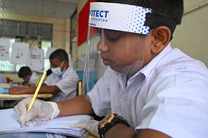 A student wearing a face shield attends school in Sri Lanka after their school was reopened this week.