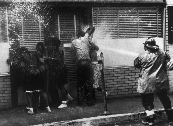 A firefighter sprays people with a high-pressure hose as they protest segregation in Birmingham, Alabama, in May 1963.