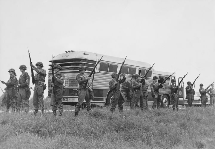 Members of the U.S. military guard a bus carrying civil rights activists known as Freedom Riders while they travel into Jacks