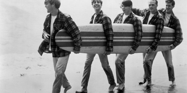Rock and roll band 'The Beach Boys' walk along the beach holding a surfboard for a portrait session in August 1962 in Los Angeles, Calif. (L-R) Dennis Wilson, David Marks, Mike Love, Carl Wilson, Brian Wilson.