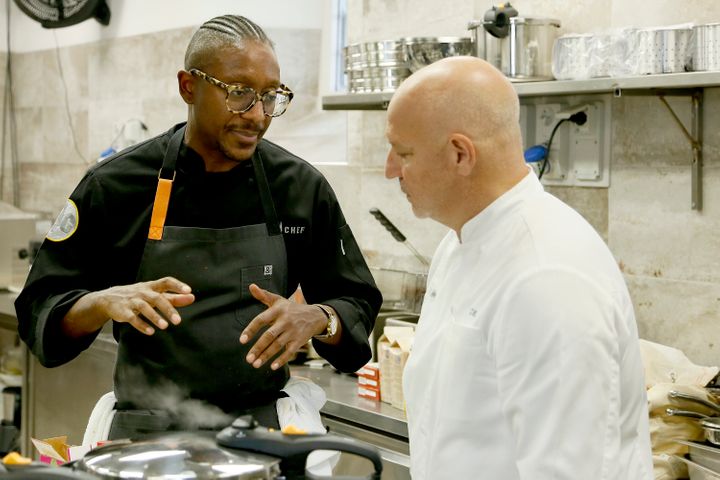Gregory Gourdet (left) speaks with judge Tom Colicchio during an episode of the Bravo series "Top Chef."