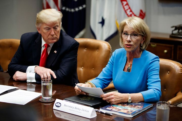 President Donald Trump listens as Education Secretary Betsy DeVos speaks during a roundtable discussion on the Federal Commis