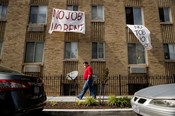 Signs that read "No job, no rent" hang from the windows of an apartment building in northwest Washington, D.C., in May. The p