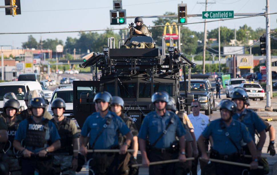 Riot police stand guard as demonstrators protest the shooting death of teenager Michael Brown in Ferguson, Missouri August 13