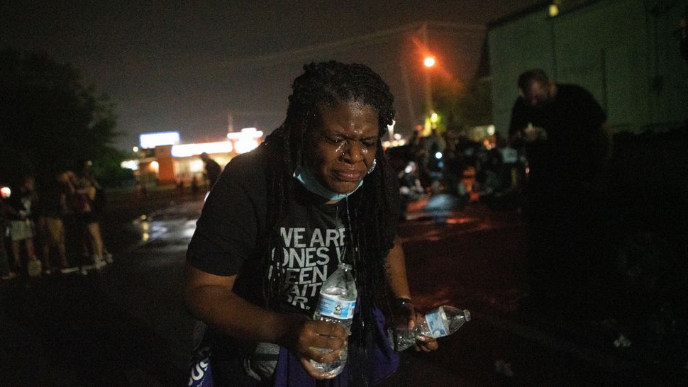 Cori Bush uses water to rinse her face after being tear-gassed by police in Florissant, Missouri, on July 5. She went back to