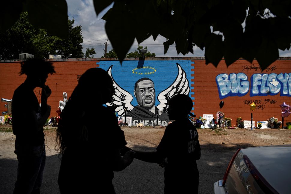 Mourners photograph a mural of George Floyd, whose death in Minneapolis police custody sparked nationwide protests against ra